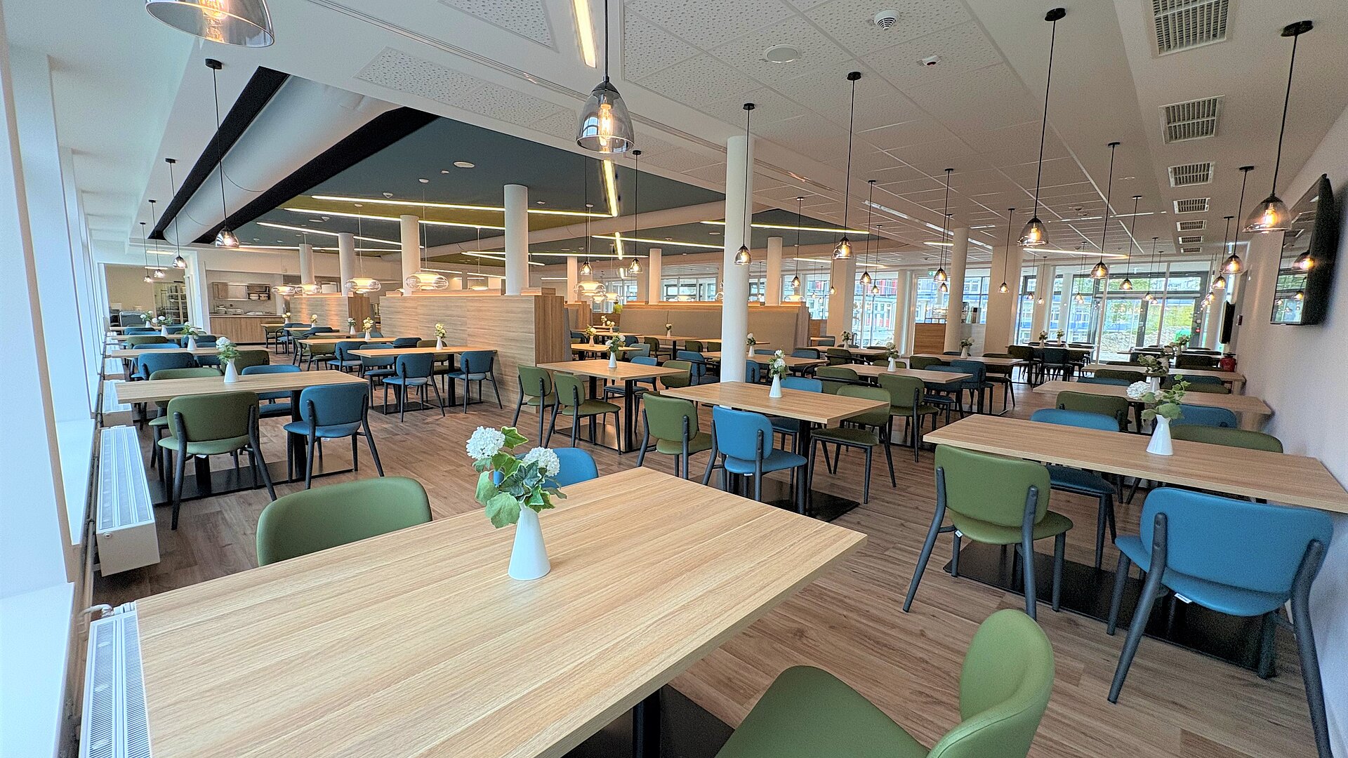 Aktuelles Ein geräumiges Restaurant mit vielen Tischen und Stühlen, wo die Gäste ihre Mahlzeiten genießen können.